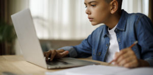 boy doing homework on laptop