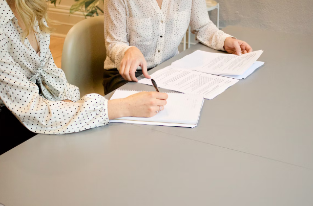 women signing documents