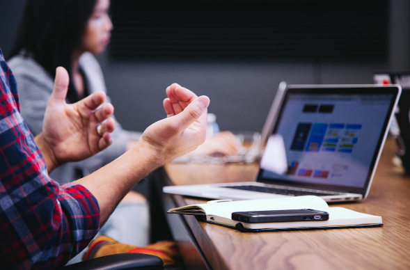 man gestures at the office table