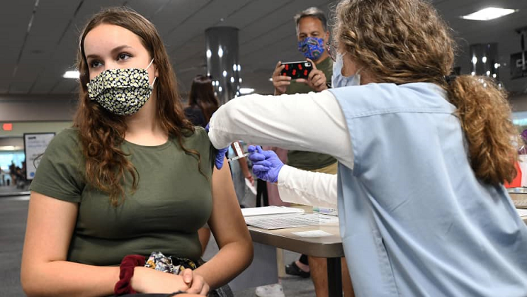 woman in green getting vaccinated 