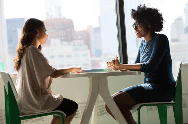 two women talking on a table