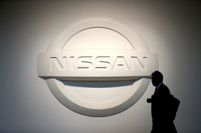 man walks by Nissan logo